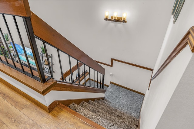 staircase featuring wood-type flooring and baseboards