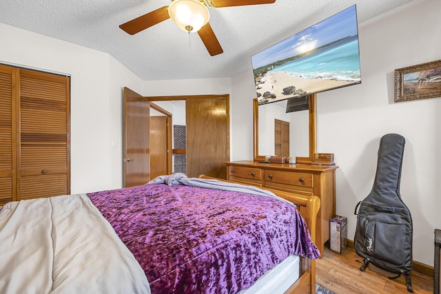 bedroom featuring a textured ceiling, a closet, a ceiling fan, and wood finished floors