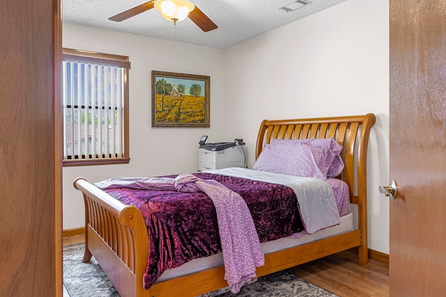 bedroom featuring a textured ceiling, hardwood / wood-style flooring, and ceiling fan