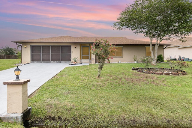 single story home featuring a garage and a lawn