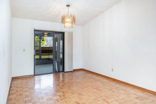 unfurnished room with light parquet flooring and a chandelier