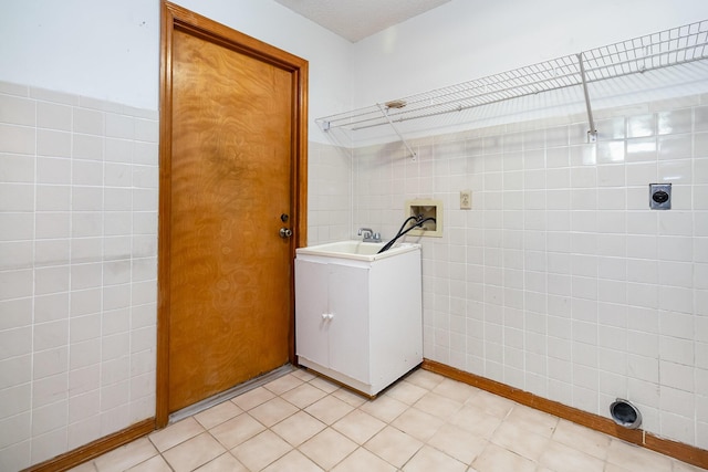 laundry room featuring sink, tile walls, hookup for a washing machine, and electric dryer hookup