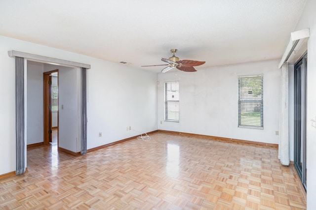 spare room with ceiling fan, light parquet floors, and a textured ceiling