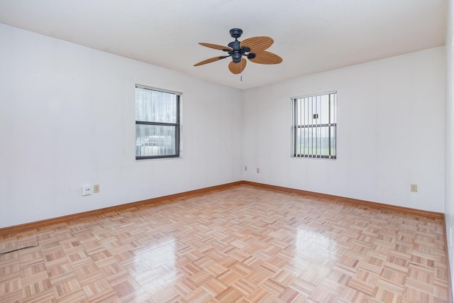 empty room featuring ceiling fan and light parquet floors