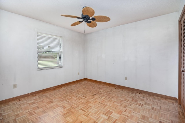 spare room with ceiling fan, light parquet floors, and a textured ceiling