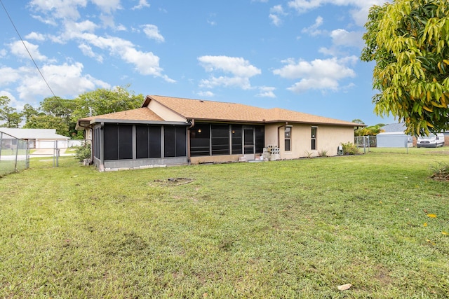 back of house featuring a sunroom and a lawn