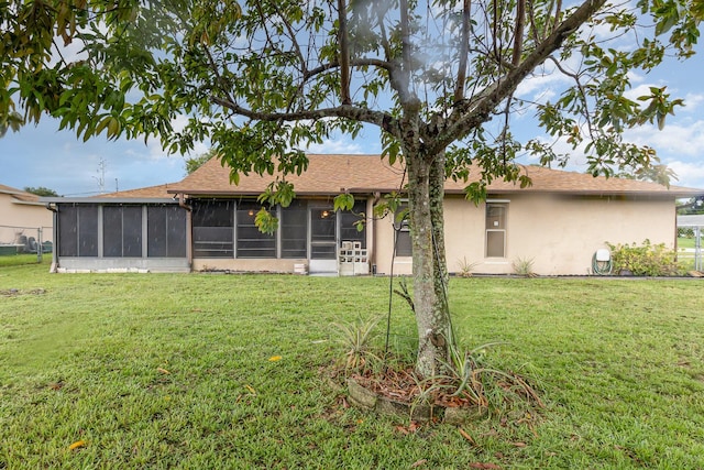 rear view of property featuring a sunroom and a yard