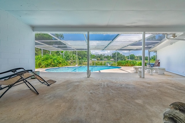 pool featuring glass enclosure and a patio area