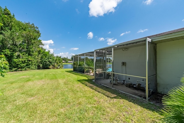 view of yard with glass enclosure and a water view