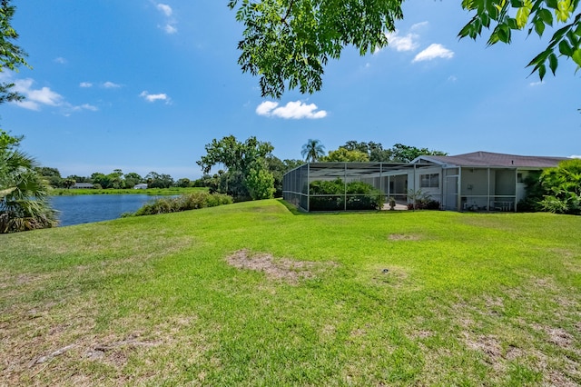 view of yard with a lanai and a water view