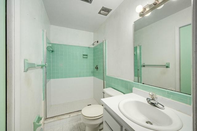 bathroom with vanity, tile walls, an enclosed shower, toilet, and tile patterned flooring