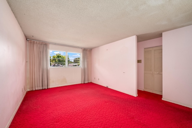 spare room featuring carpet flooring and a textured ceiling