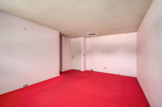 spare room featuring carpet floors and a textured ceiling