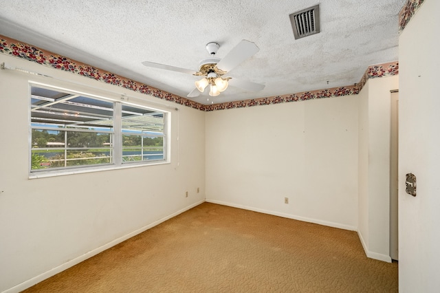 carpeted empty room featuring a textured ceiling and ceiling fan