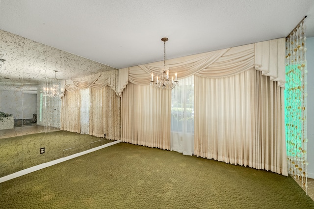 carpeted empty room featuring a chandelier