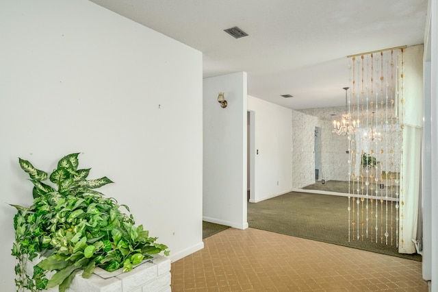 hall with tile patterned flooring and a chandelier