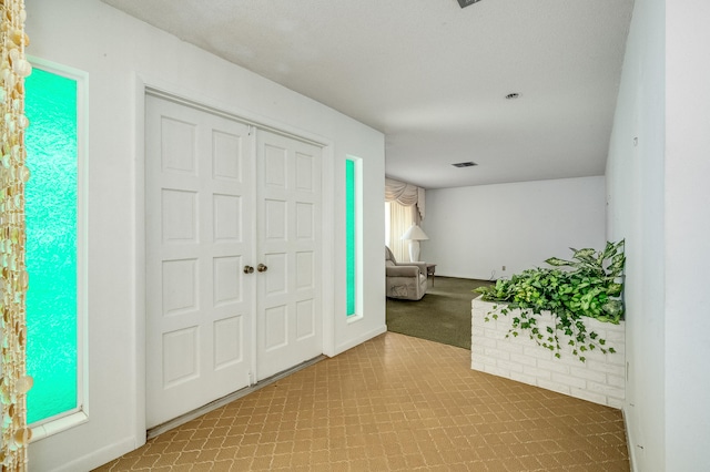 view of carpeted foyer entrance