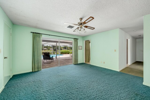 unfurnished room with dark colored carpet, a textured ceiling, and ceiling fan