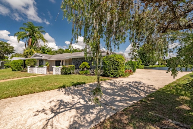 view of front of house with concrete driveway and a front lawn