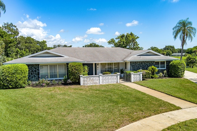 ranch-style home featuring a front yard and fence