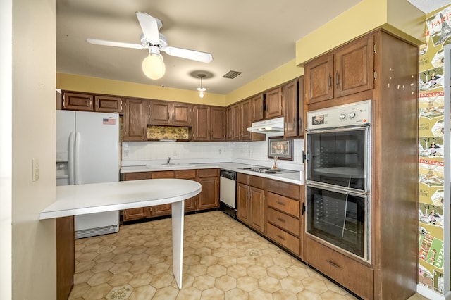 kitchen featuring tasteful backsplash, white appliances, sink, light tile patterned floors, and ceiling fan