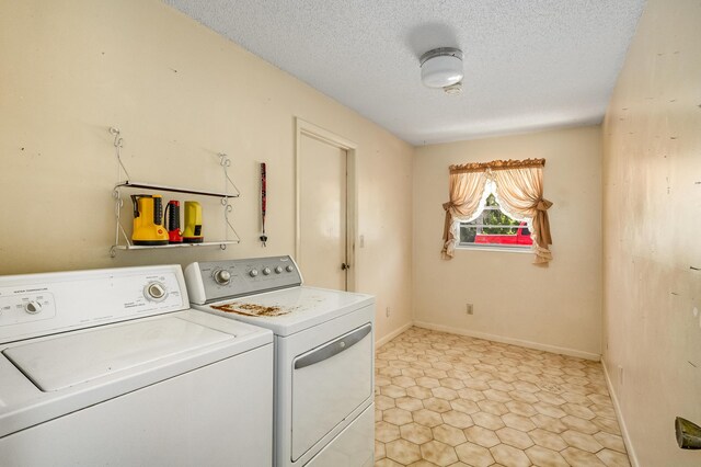 laundry room featuring light tile patterned flooring, washer and clothes dryer, and a textured ceiling