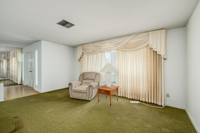 unfurnished room featuring visible vents, carpet floors, and a textured ceiling