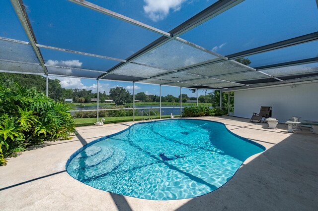 view of swimming pool with a patio area and a lanai