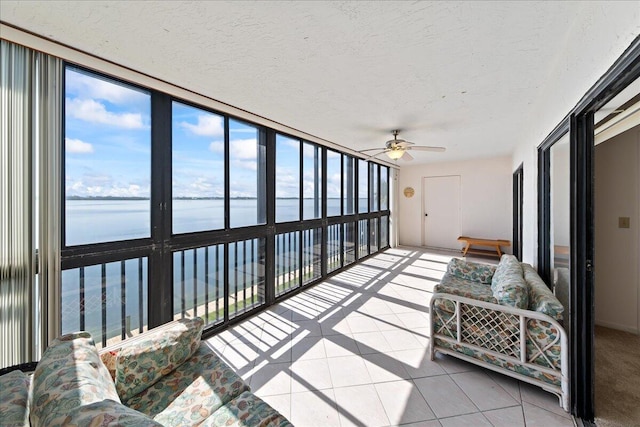 sunroom / solarium with a water view and ceiling fan