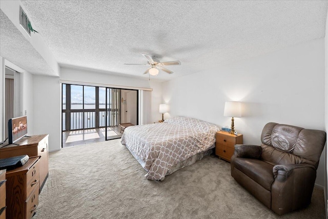 bedroom featuring light carpet, access to exterior, a textured ceiling, and ceiling fan