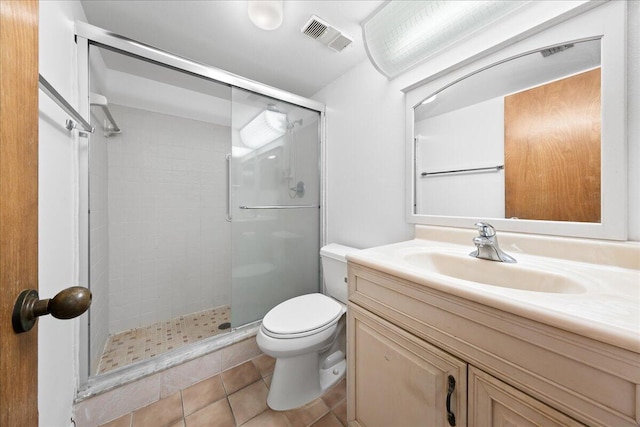 bathroom with vanity, a shower with shower door, tile patterned floors, and toilet