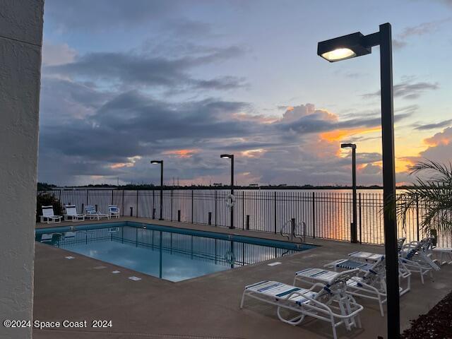 pool at dusk with a patio