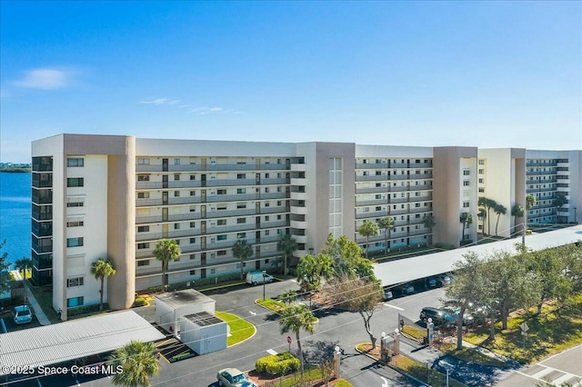 view of property with a water view and uncovered parking