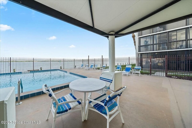 view of swimming pool with a patio and a water view