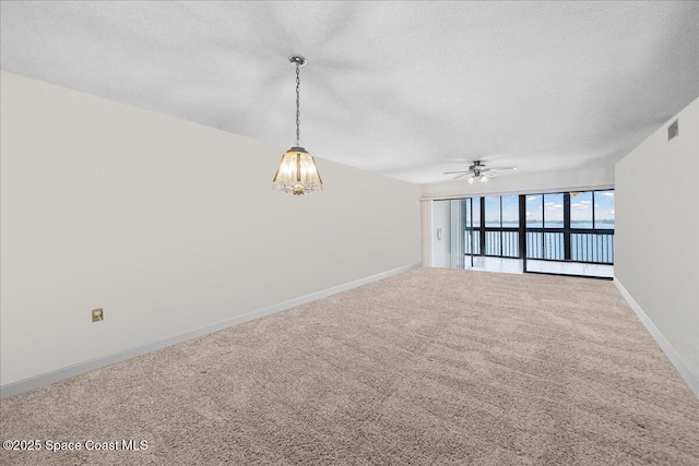 250 S Sykes Creek Pkwy Unit 309, Merritt Island, FL 32952 - empty room featuring a textured ceiling, carpet floors, ceiling fan, baseboards, and a chandelier
