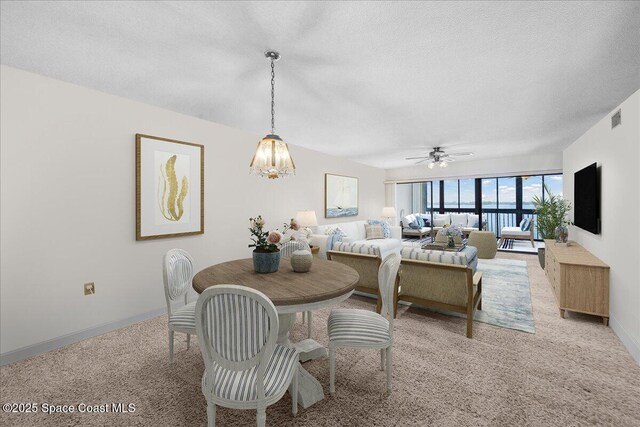 250 S Sykes Creek Pkwy Unit 309, Merritt Island, FL 32952 - dining area with baseboards, ceiling fan, carpet flooring, a chandelier, and a textured ceiling
