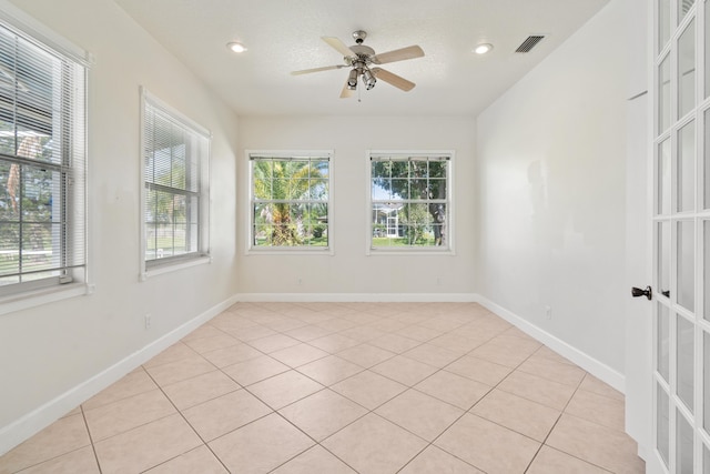 unfurnished room featuring ceiling fan, light tile patterned floors, and a textured ceiling