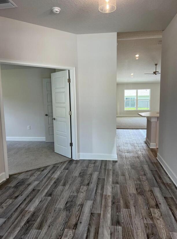 interior space with a textured ceiling and dark wood-type flooring