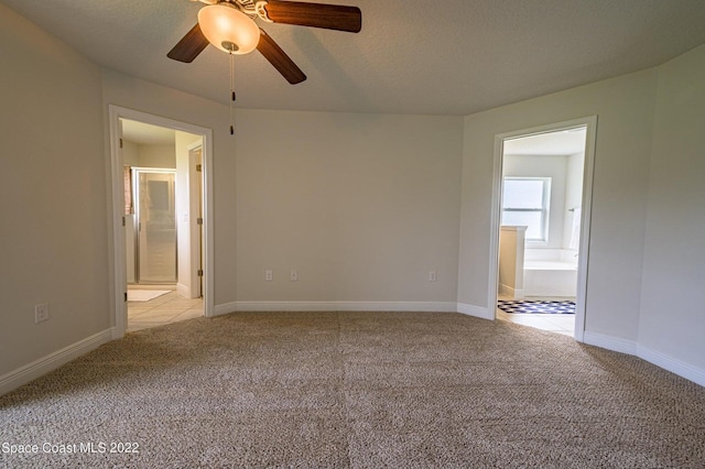 carpeted spare room featuring a textured ceiling and ceiling fan