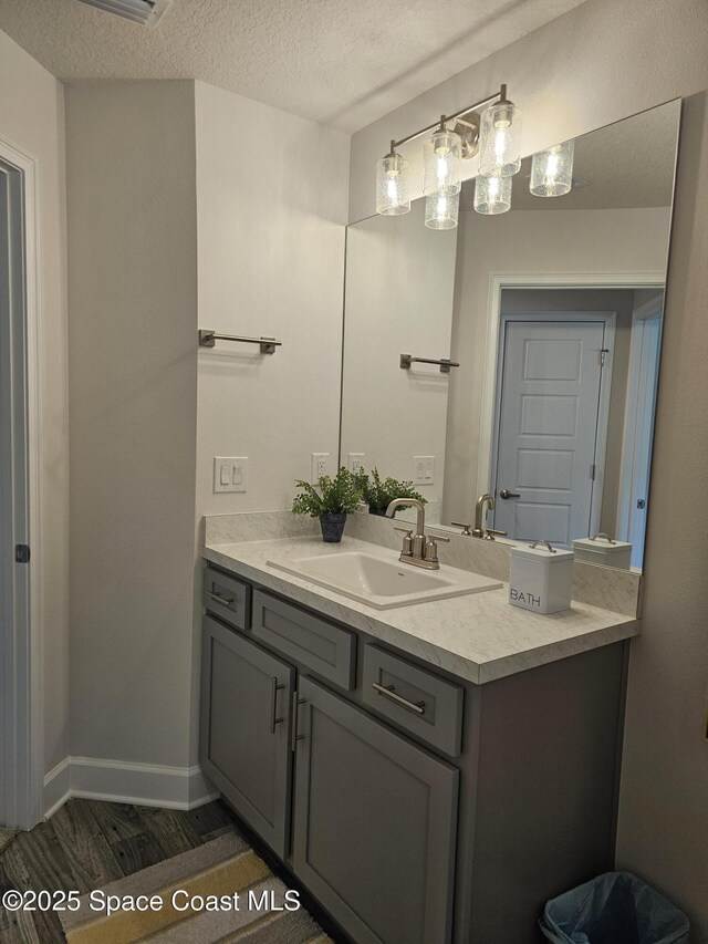 920 Lyons Cir NW, Palm Bay, FL 32907 - bathroom with vanity, wood finished floors, a textured ceiling, and baseboards