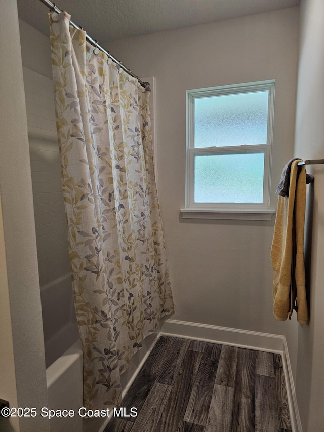 920 Lyons Cir NW, Palm Bay, FL 32907 - bathroom featuring baseboards, shower / tub combo with curtain, and wood finished floors
