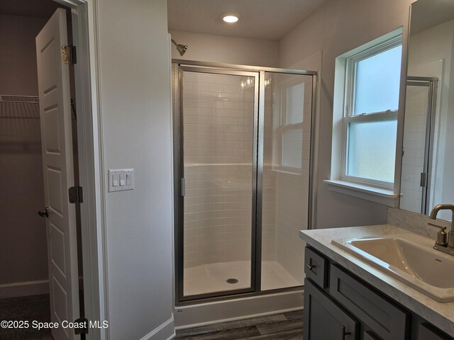 920 Lyons Cir NW, Palm Bay, FL 32907 - full bathroom with a stall shower, vanity, a walk in closet, wood finished floors, and recessed lighting