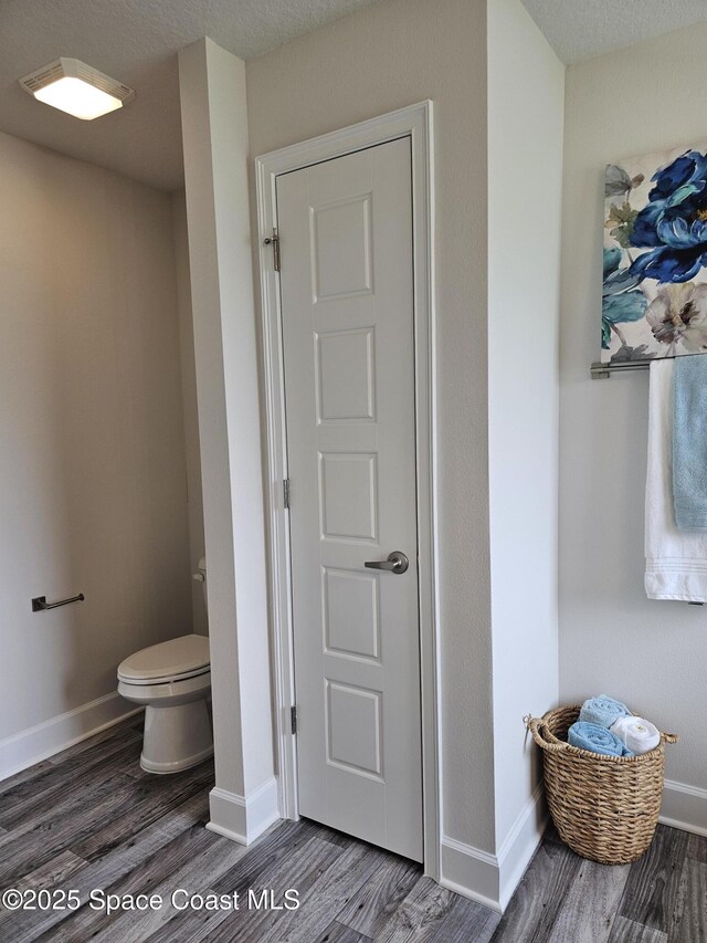 920 Lyons Cir NW, Palm Bay, FL 32907 - bathroom featuring wood finished floors, toilet, and baseboards