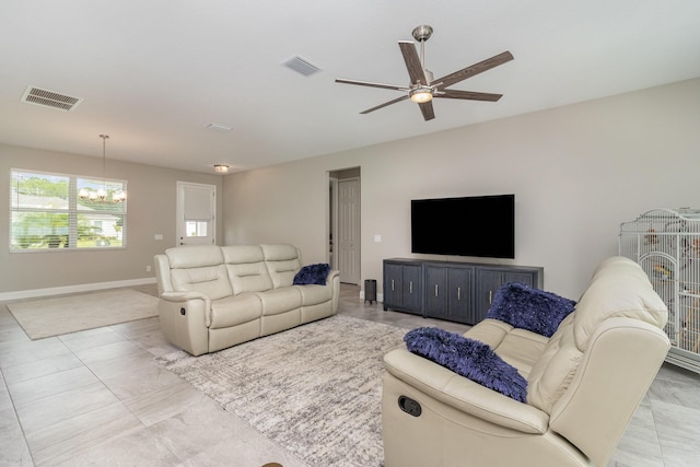 tiled living room featuring ceiling fan with notable chandelier