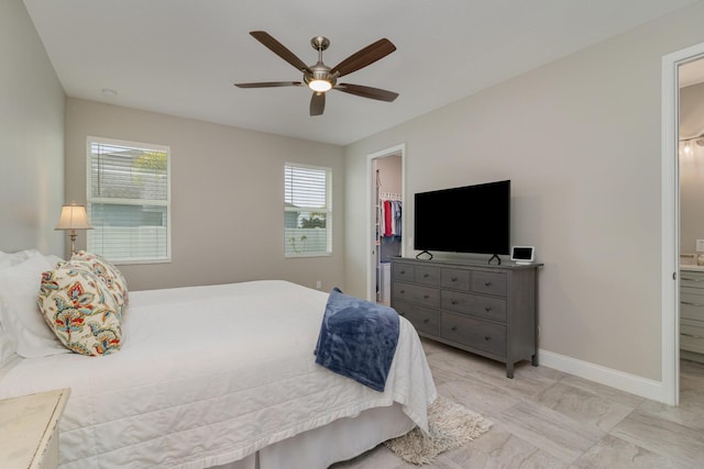 bedroom with ensuite bathroom, a spacious closet, ceiling fan, and a closet