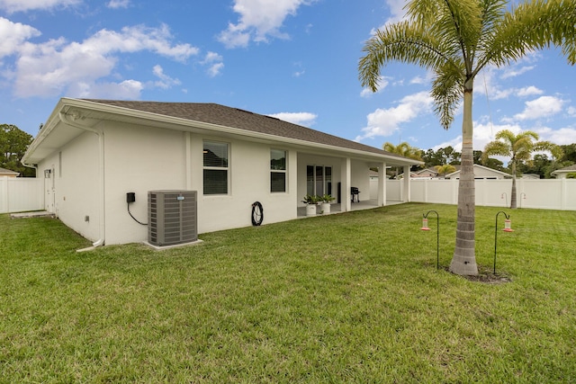 back of property featuring a patio, a lawn, and central air condition unit