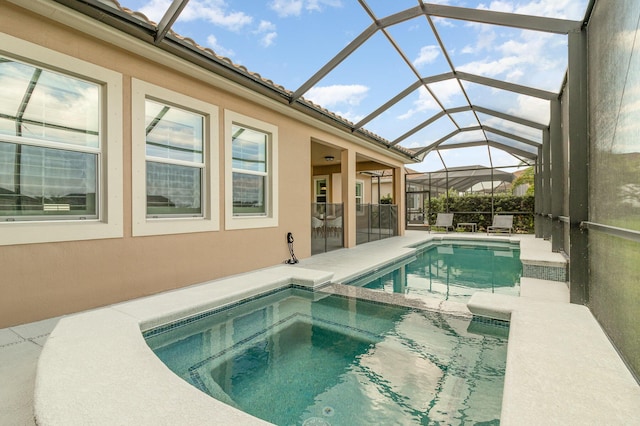 view of pool featuring a lanai, a patio area, and an in ground hot tub