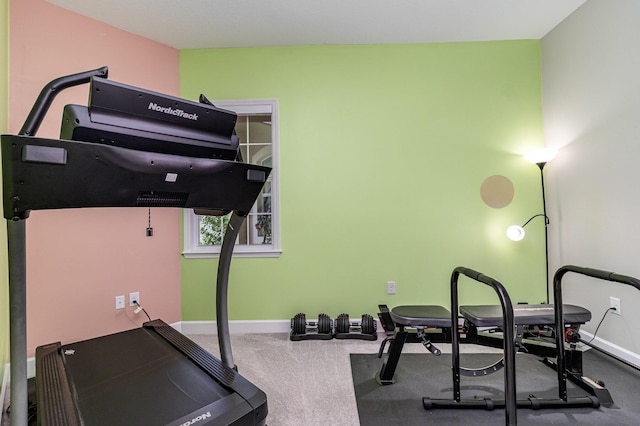 workout area featuring baseboards and carpet flooring