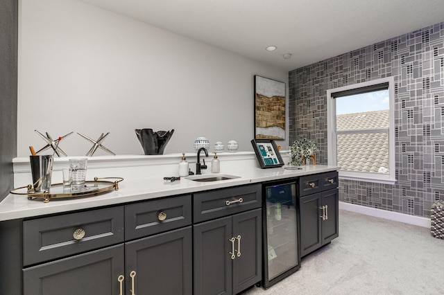 bar with beverage cooler, light colored carpet, and a sink