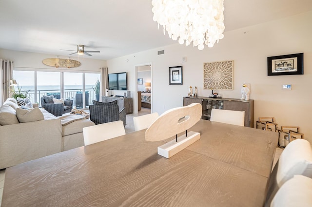 dining room with ceiling fan with notable chandelier